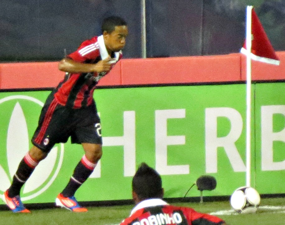 Jugador ejecutando un tiro de esquina en un partido nocturno
